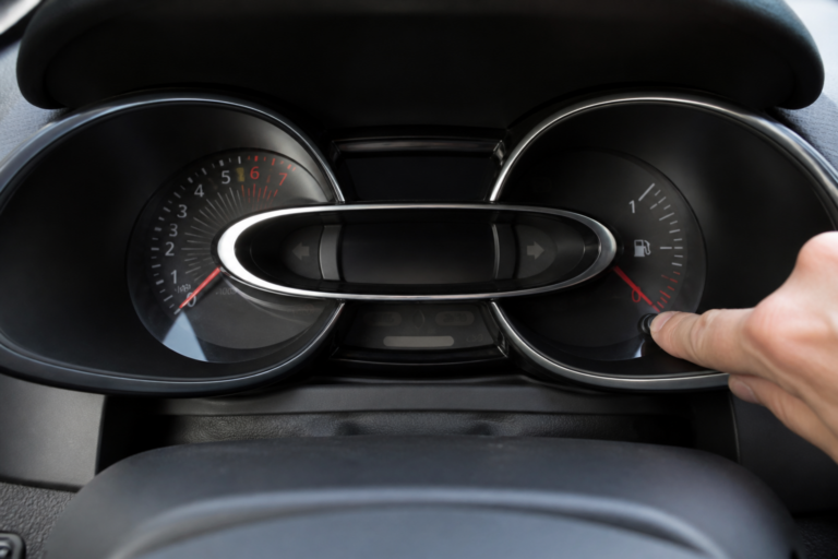 Tableau de bord Renault Clio 4 avec témoin de vidange éteint, main sur bouton de réinitialisation